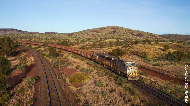 Ein Güterzug fährt durch die australische Wüstenlandschaft.